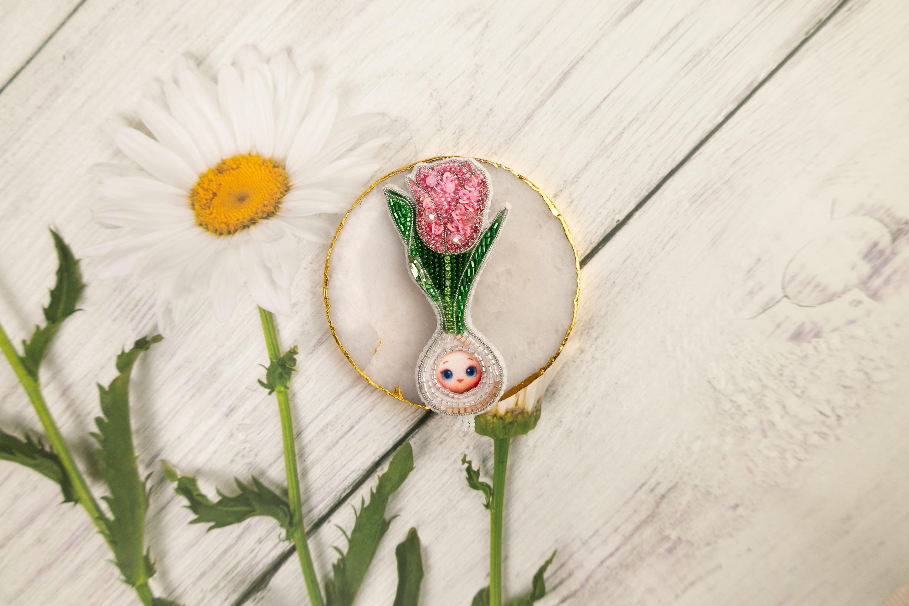 a white flower and a pink flower on a white table